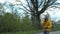 Pensioner in mask gloves rides scooter along village road