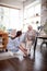 Pensioner smiling while caregiver lacing shoes for her