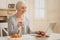 Pensioner smiling while watching family photos on laptop