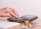 A pensioner sums up his money on a calculator. Hand of an old woman and a calculator close-up