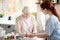 Pensioner taking vitamins standing near caregiver