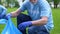 Pensioner volunteer collecting plastic bottles, nature protection, eco-activism