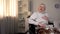 Pensioner in wheelchair feeling chest pain, heart attack, myocardial infarction