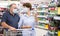 Pensioners in protective masks choose alcoholic beverages in supermarket