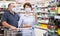 Pensioners in protective masks choose alcoholic beverages in supermarket