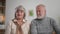 pensioners talk and show pills on webcam, portrait of gray-haired grandparents communicate with a doctor via the