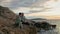 pensioners travel, joyful old man and his wife enjoy their vacation sitting on seashore backdrop of sunset