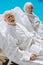 Pensioners wearing eye patches and white bathrobes lying near pool