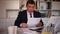 Pensive adult businessman sitting at office desk, working with papers