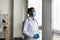 Pensive African American man doctor wearing medical mask thinking