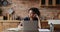 Pensive African woman working on laptop at home