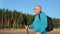 Pensive backpacker grandfather elderly man Scandinavian walking stick sport forest sky landscape