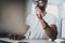 Pensive bearded coworker wearing eye glasses and working at modern loft studio-office.Blurred background. Horizontal.