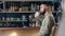 Pensive bearded male drinking coffee at cafeteria sitting on table. Medium shot on red camera