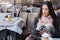 Pensive, beautiful and elegant woman sitting on an european cafe