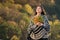 Pensive beautiful girl with autumn leaves in her hands. Dream thoughts about life