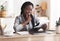 Pensive black businesswoman checking financial reports at workplace in office