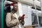 Pensive Black man in subway train thinking using cellphone listens to music with wireless headphones