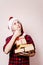 Pensive boy in Santa hat with stack of gift boxes