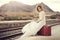 Pensive bride with a red suitcase