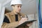 Pensive builder standing with clipboard in hands