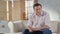 Pensive businessman sitting in light office room, looking satisfied with life