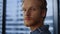 Pensive businessman standing in office lobby. Entrepreneur looking at window