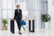 pensive businesswoman in suit and eyeglasses leaning on table