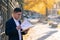 Pensive caucasian realtor in classic tie suit standing outside hold clipboard with papers and read document
