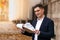 Pensive caucasian realtor in classic tie suit standing outside hold clipboard with papers and read document