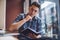 Pensive Caucasian schooler with notebook in hand posing indoors