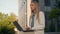 Pensive Caucasian woman businesswoman student female business lady girl developer think typing on laptop outdoors street