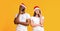Pensive couple wearing santa hats and posing with thoughtful face expression