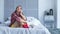 Pensive depressed woman sitting and thinking on bed