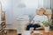 Pensive elderly lady sitting with a book in an armchair in a nursing home