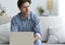 Pensive Entrepreneur At Laptop Thinking Sitting On Couch