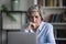 Pensive focused elderly businesswoman working on computer.