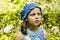 Pensive girl 8-9 years old in knitted blue hat.