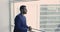 Pensive Indian businessman in suit standing indoors looking out window