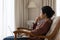 Pensive Indian woman sit on armchair with laptop