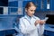 Pensive laboratory technician in lab coat looking at samples