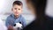 Pensive little child boy holding toy at kid psychotherapy session medium close-up