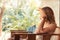 Pensive lonely beautiful tanned woman wet hair relaxing outdoors in chair and looking away during tropical summer beach holidays