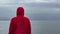 Pensive lonely man standing in the rain on the beach and gazing