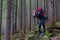 Pensive Male Hiker Staying on Stone in Forest