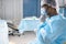 Pensive male surgeon in protective workwear sitting in front of operating table