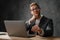 The pensive man in headphones and glasses wrinkling his forehead while sitting at the table