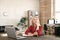Pensive mature blond businesswoman sitting in front of laptop and contemplating