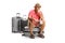 Pensive mature male toruist sitting on a suitcase and waiting for a flight