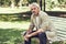 Pensive mature man sitting on bench in an urban park.